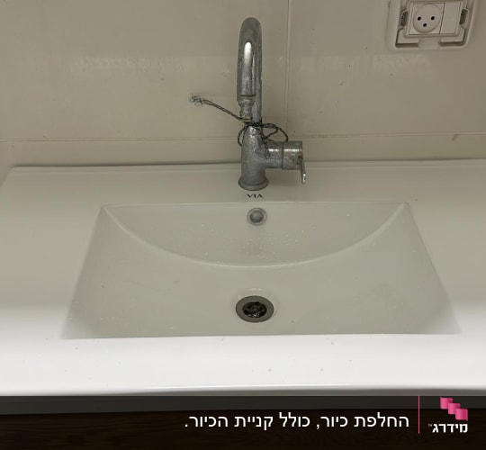 כיור עם ברז מותקן על קיר לבן